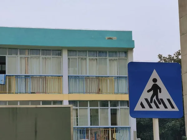 street sign, pedestrian crossing, road signs, blue sky, white, green, yellow, black,