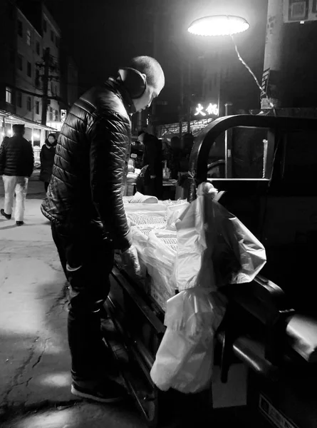 black and white photo of a man in a suit with a bag