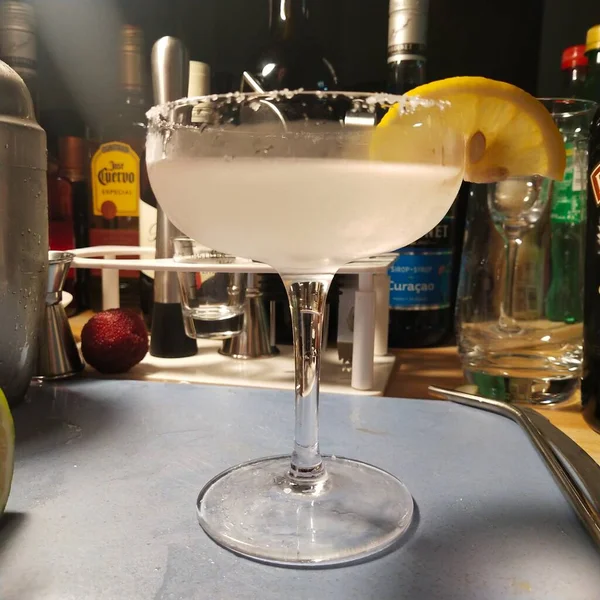 cocktail with lemon and ice cubes on the bar counter