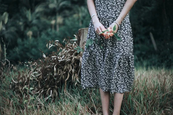 young woman in a dress with a bag of flowers