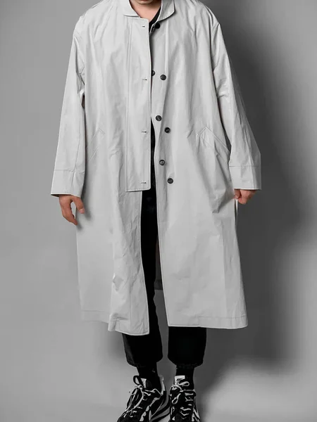 young doctor in a white coat and a stethoscope on a gray background.