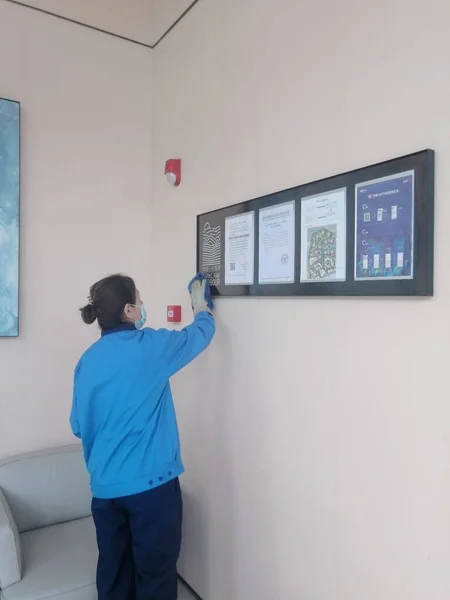 young man with a blue t-shirt and a white wall with a large window