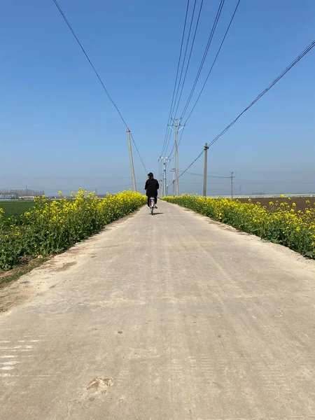 a man in a green dress on a road in the city