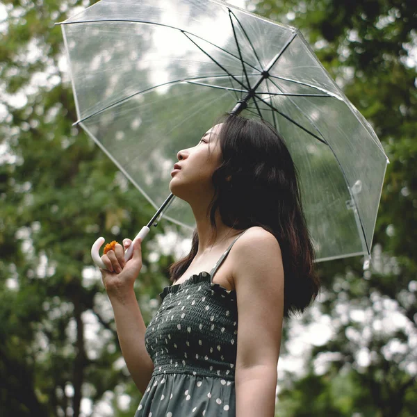young woman with umbrella in the park