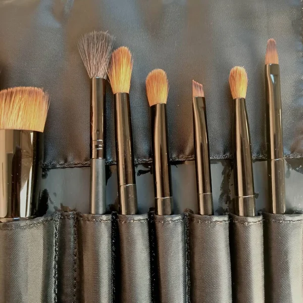 set of brushes for makeup and brush on a black background