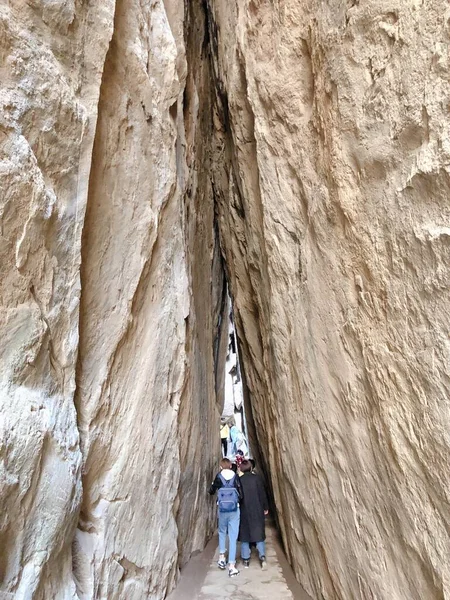 the man is climbing the wall of the cave