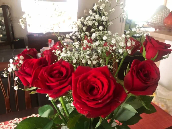 beautiful roses in a vase on a background of a red rose