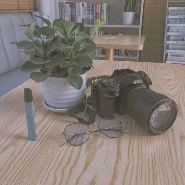 digital photo camera and tablet computer with a wooden table and a laptop