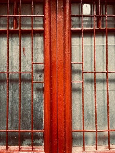 red and black metal fence with a wooden background