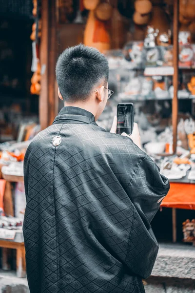 man in a jacket and jeans standing in a shop