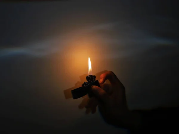 burning candle in the hands of a man