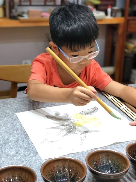 little boy draws a picture of a child