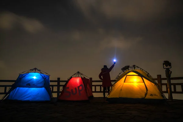 camping tent with a bonfire on the background of the night sky