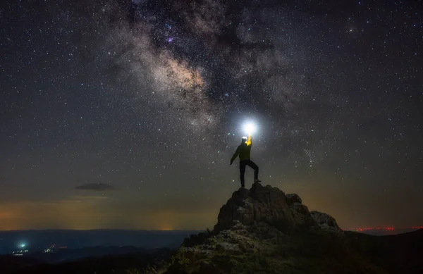 silhouette of a man standing on a rock with a star on the background of the mountains