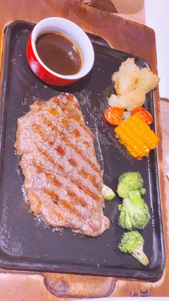 grilled pork steak with sauce and vegetables