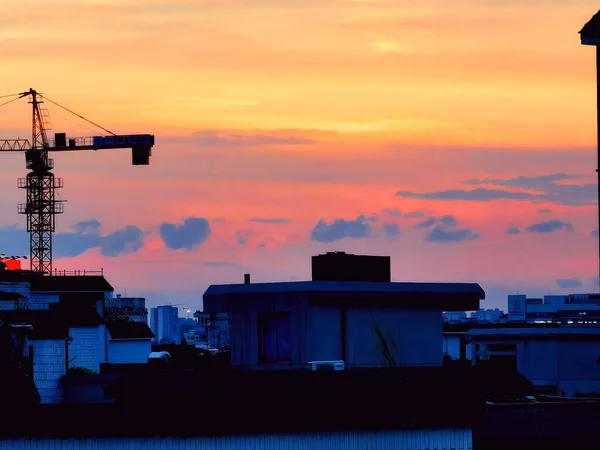 silhouette of a building with cranes and a crane
