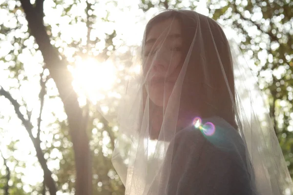 young woman with a veil in the park