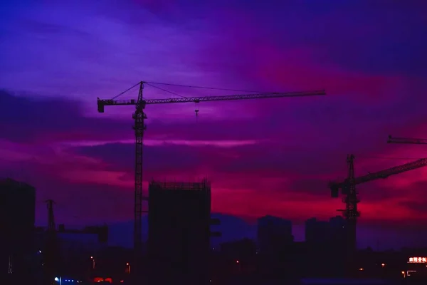 silhouette of a building with a crane