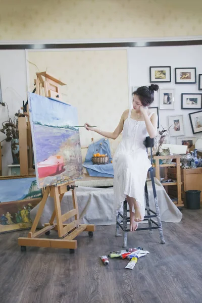 young woman artist painting a picture of a beautiful girl