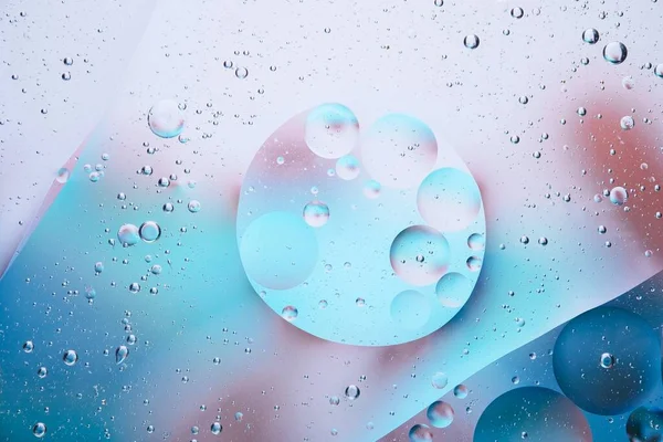 abstract background with colorful oil drops and water droplets on blue glass