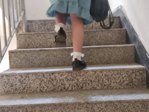 young woman with backpack walking on stairs