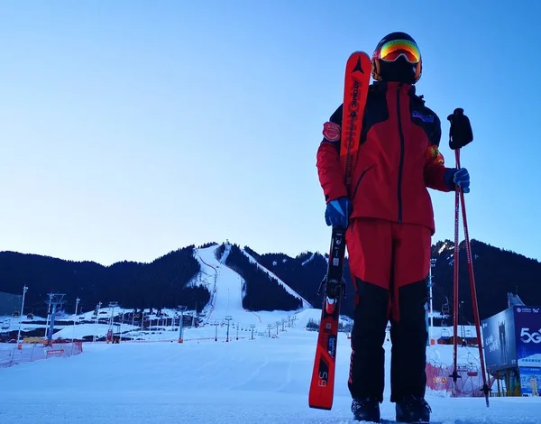 young woman with backpack and ski poles on the background of the mountain.