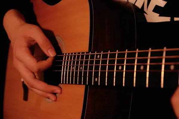 close up of a female hand holding a guitar