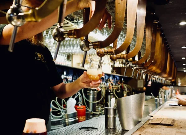 bartender pouring beer into a glass