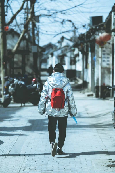 young man with backpack walking in the city