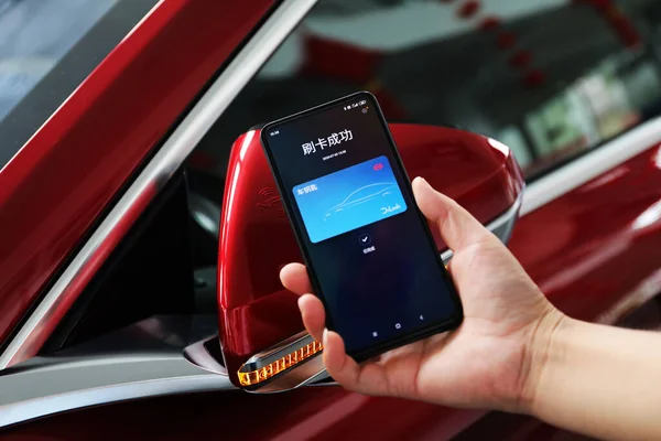 woman hand holding smartphone with car on screen