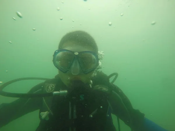 underwater view of a man in a green tank