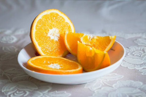 fresh orange and sliced oranges on a wooden table