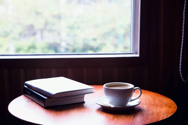 coffee cup and book on wooden table