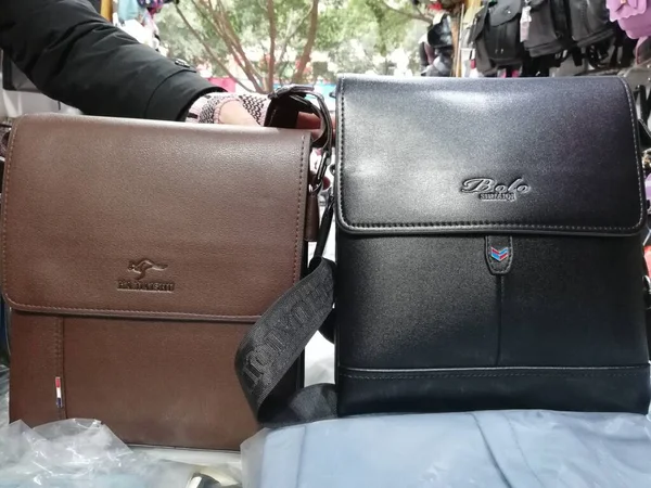 woman\'s hands with leather bag on the background of the old wooden window