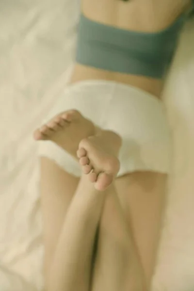 close up of a woman\'s feet on a bed