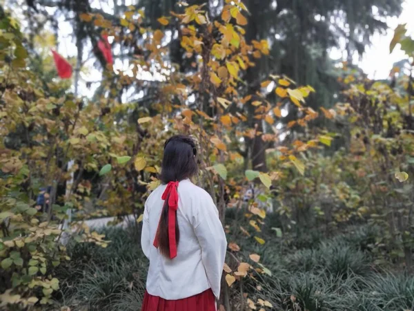 young woman in red raincoat in autumn park