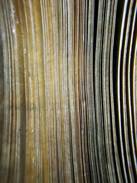 close up of a stack of paper with a wooden surface