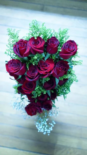 beautiful bouquet of roses in a vase on a wooden background.
