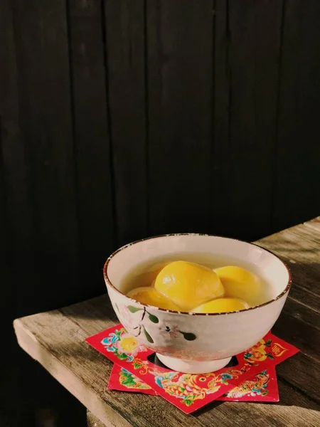 a bowl of fresh mango fruits on a wooden table