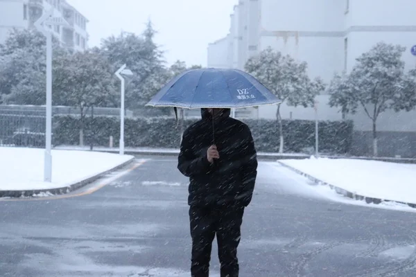 man in a jacket with a umbrella in the city