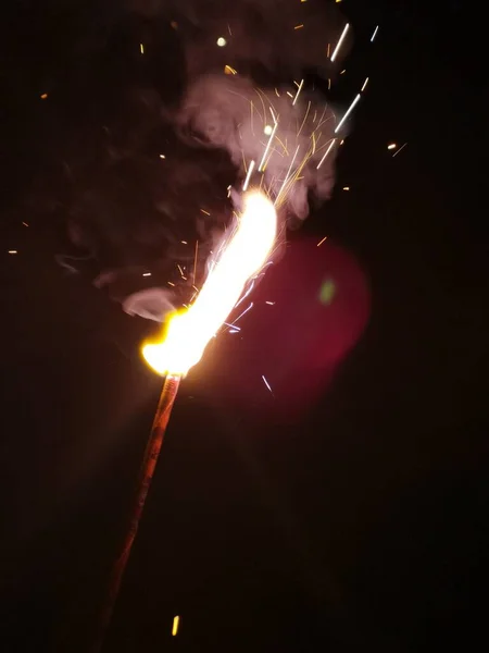 sparks with burning sparkler on dark background