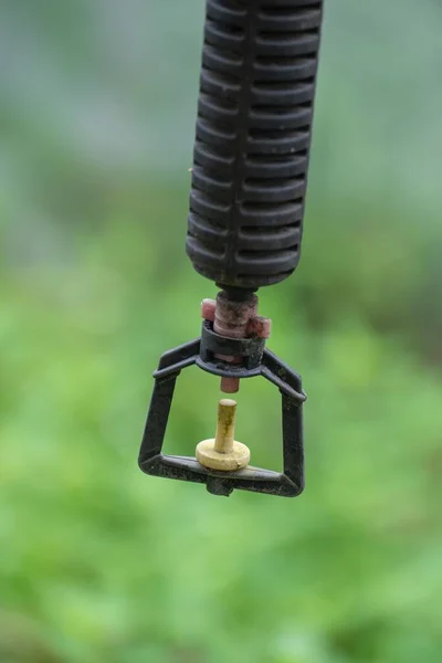a closeup shot of a rusty metal detector with a blurred background