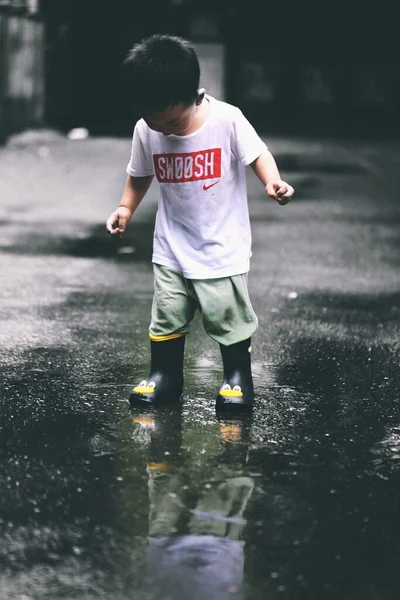 little boy running in the rain