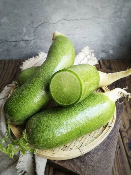 fresh green zucchini in a basket on a wooden background
