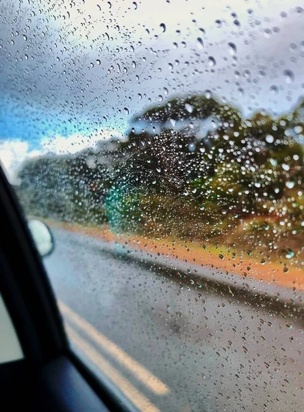 car window with rain drops on the glass
