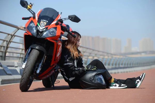 young woman with motorcycle helmet and sunglasses on the street