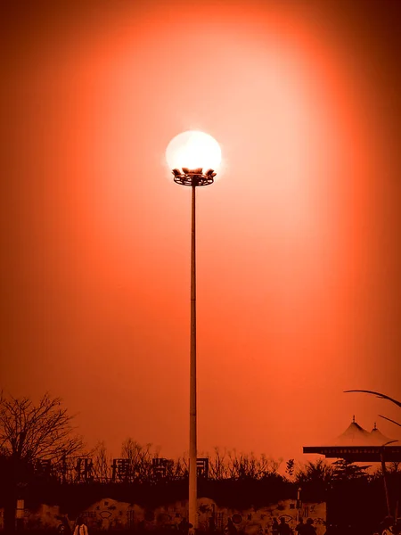 silhouette of a street lamp on a background of sunset