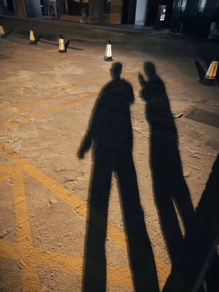 silhouette of a man and woman walking in the city