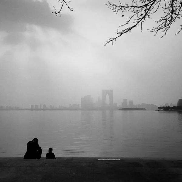 silhouette of a man and woman on the background of the lake