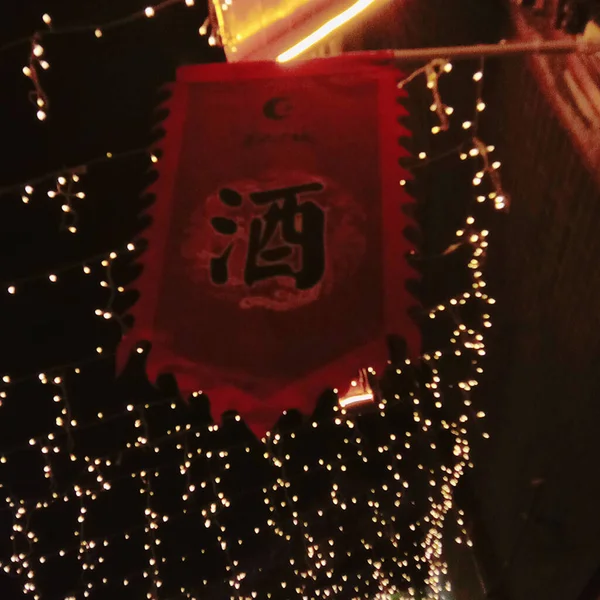 close up of a red and white lantern with a burning candle